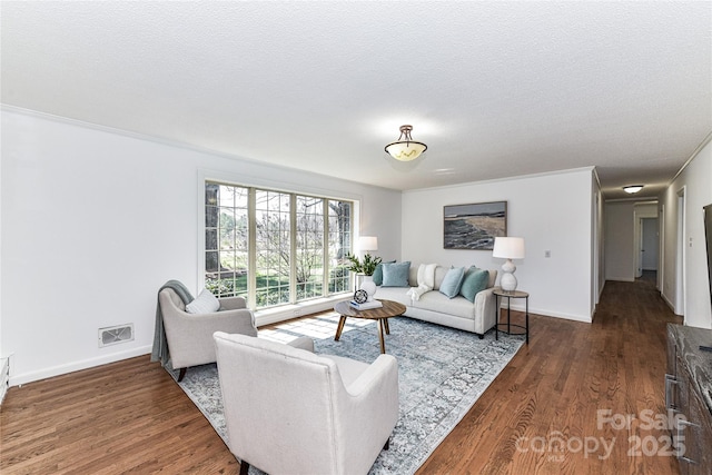 living room with wood finished floors, visible vents, and a textured ceiling