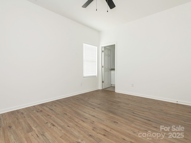 spare room with a ceiling fan, baseboards, and wood finished floors