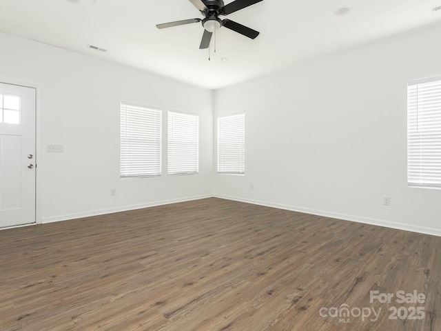 unfurnished room with baseboards, wood finished floors, visible vents, and a ceiling fan