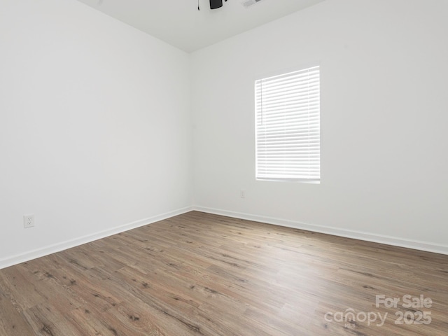 unfurnished room featuring visible vents, ceiling fan, baseboards, and wood finished floors