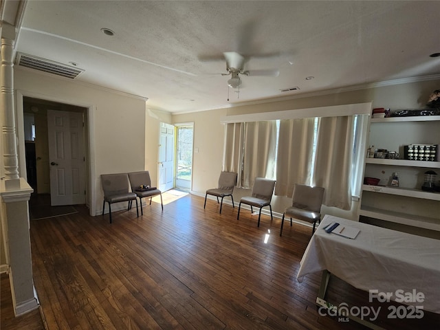 living area featuring ceiling fan, ornamental molding, hardwood / wood-style flooring, and visible vents