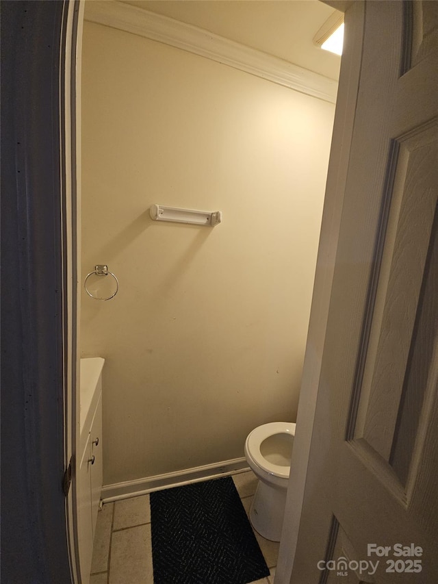 bathroom featuring baseboards, toilet, ornamental molding, tile patterned floors, and vanity