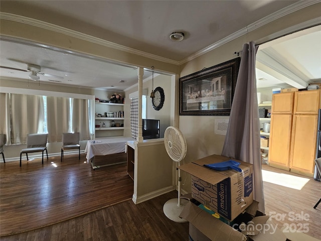 interior space featuring a ceiling fan, crown molding, baseboards, and wood finished floors