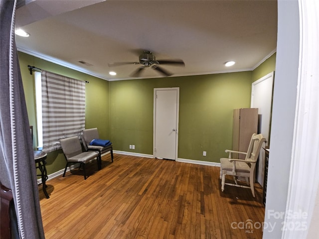 living area with baseboards, hardwood / wood-style flooring, ceiling fan, ornamental molding, and recessed lighting