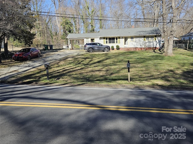 view of front of home featuring fence, a front lawn, and a carport