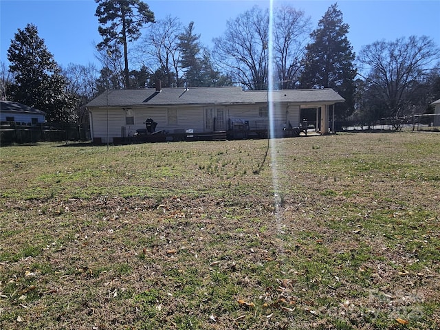 back of property with fence and a lawn