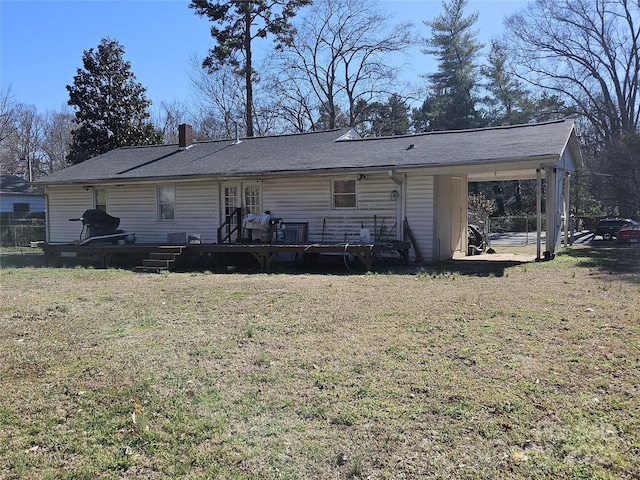 back of house with a deck, a carport, a lawn, and a chimney