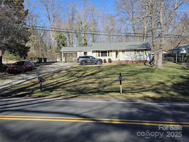 ranch-style home featuring a front yard and fence