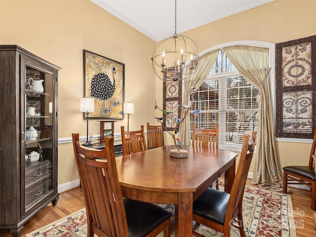 dining room with light wood-style floors, baseboards, a chandelier, and ornamental molding