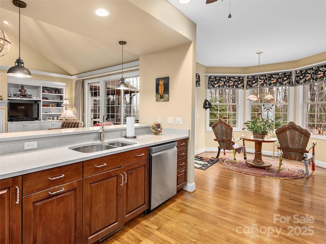 kitchen with dishwasher, light wood-type flooring, a sink, and pendant lighting