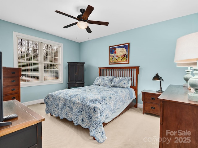 bedroom featuring light carpet, ceiling fan, and baseboards