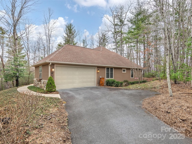 single story home featuring aphalt driveway, roof with shingles, and an attached garage