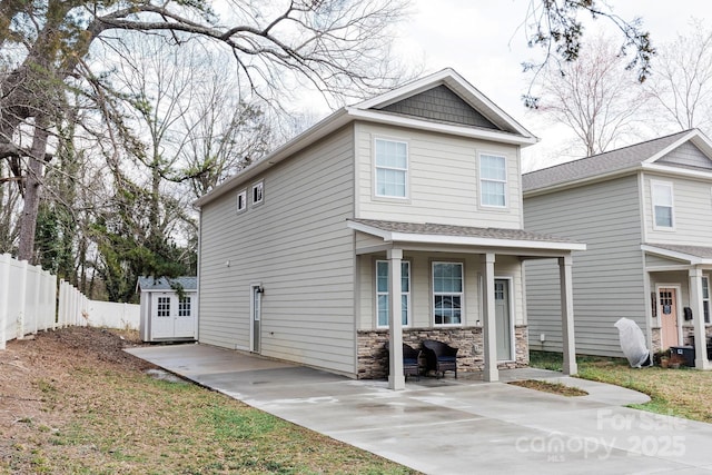 view of front of house with stone siding and fence