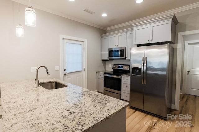 kitchen with light stone counters, stainless steel appliances, light wood-style floors, ornamental molding, and a sink