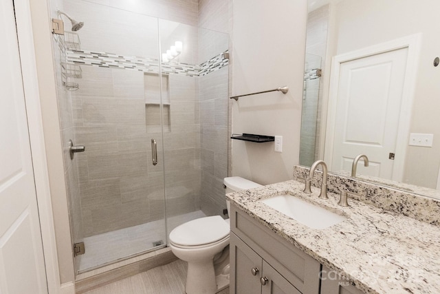 full bath featuring vanity, a shower stall, and toilet