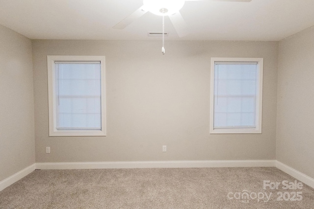 unfurnished room with light carpet, baseboards, visible vents, and a ceiling fan