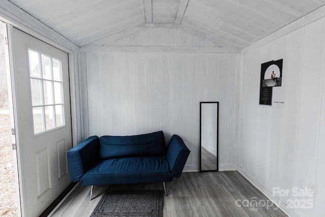 living area with vaulted ceiling with beams and wood finished floors