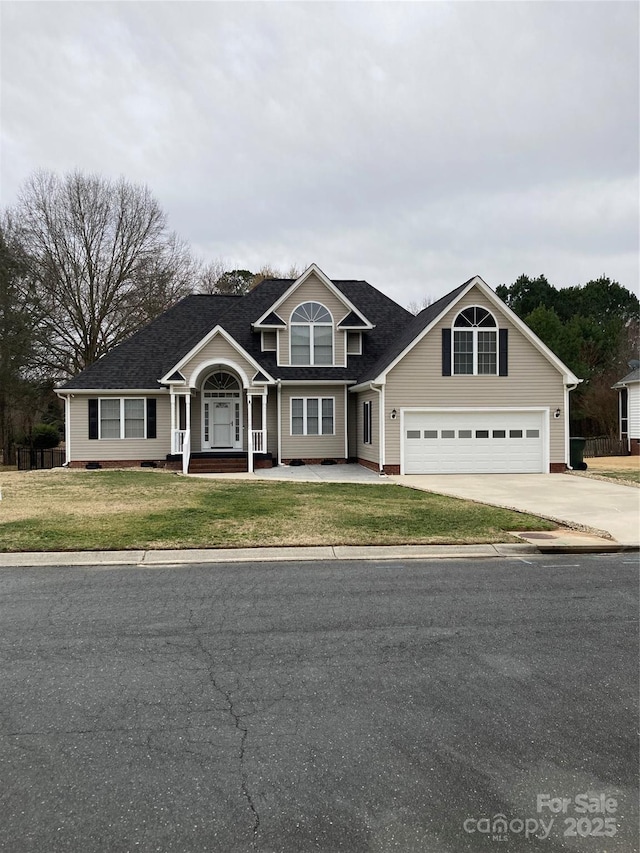 traditional-style home with driveway, a garage, and a front lawn