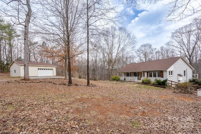 single story home with a porch, an outbuilding, and a detached garage