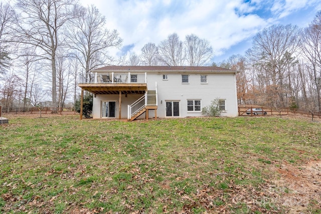 back of property featuring stairway, a lawn, a deck, and fence