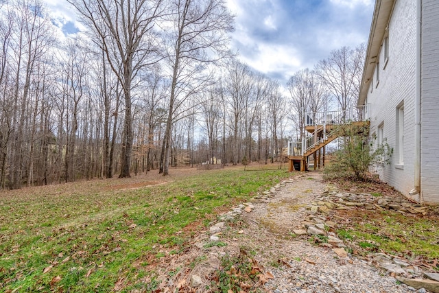 view of yard featuring a wooden deck and stairs