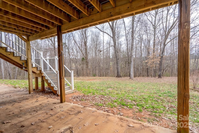 view of yard featuring a view of trees and stairs