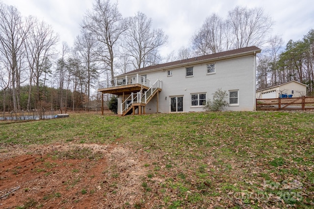 back of property with a yard, a deck, stairs, and fence