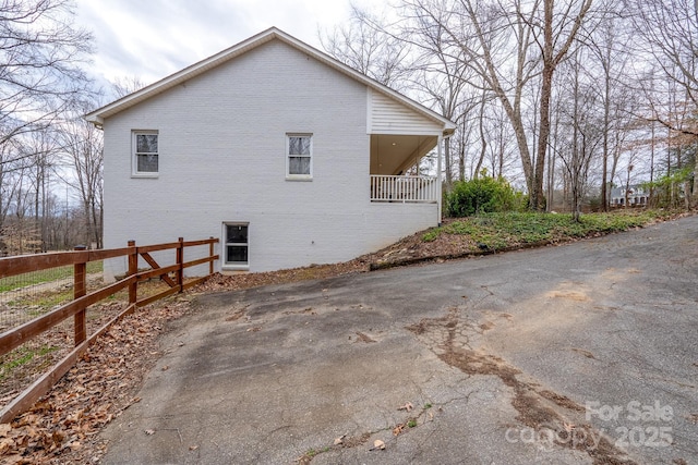 view of side of property with brick siding and fence