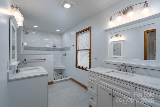 full bath featuring recessed lighting, a walk in shower, two vanities, and a sink