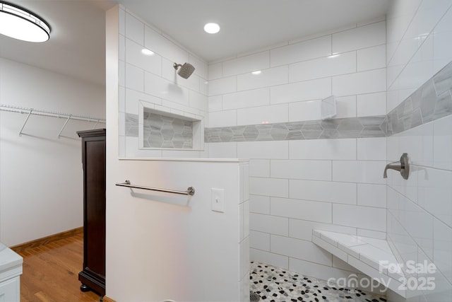 bathroom featuring recessed lighting, wood finished floors, and a tile shower