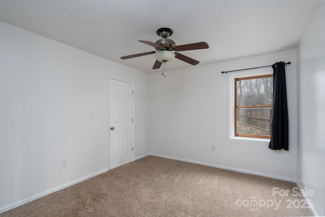 unfurnished room with carpet flooring, baseboards, and a ceiling fan