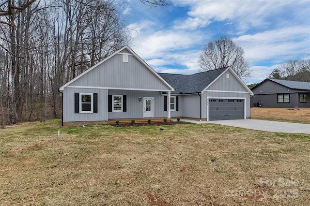 view of front of property featuring a front yard, covered porch, a shingled roof, concrete driveway, and a garage