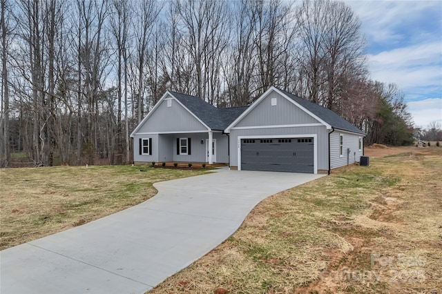 view of front of home featuring cooling unit, roof with shingles, concrete driveway, a front yard, and a garage