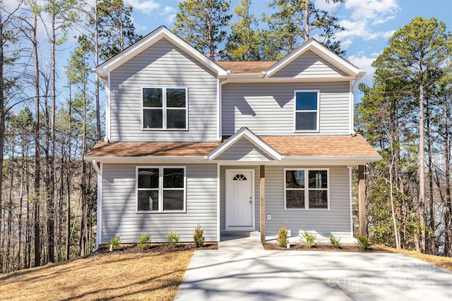 traditional home featuring roof with shingles