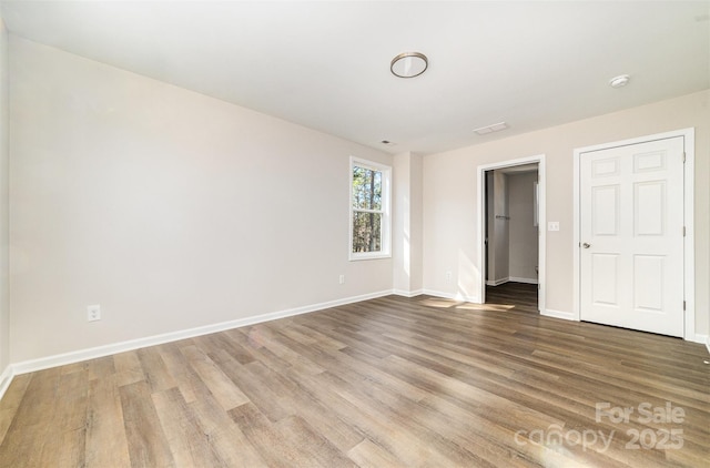 unfurnished bedroom with wood finished floors and baseboards