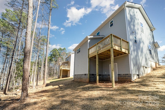 rear view of property with crawl space and a wooden deck