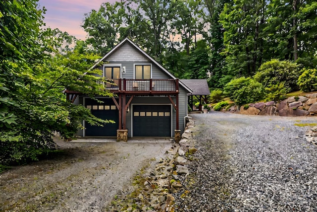 rustic home with driveway, a wooden deck, and a garage