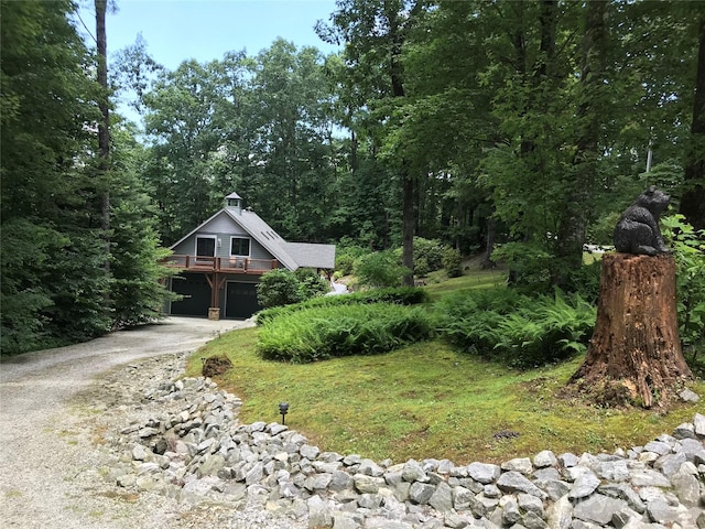 view of front facade featuring driveway, a garage, and a wooden deck