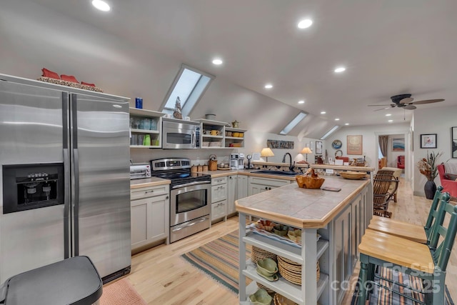 kitchen featuring open shelves, appliances with stainless steel finishes, a sink, a peninsula, and recessed lighting