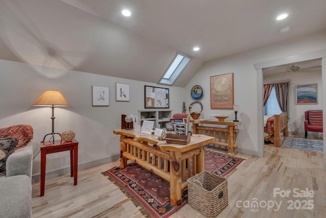 home office featuring a skylight, lofted ceiling, baseboards, light wood-type flooring, and recessed lighting