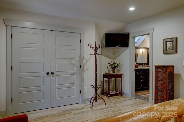entryway featuring wood finished floors, a sink, and recessed lighting