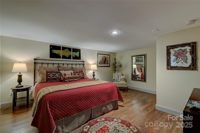 bedroom with wood finished floors, baseboards, and recessed lighting
