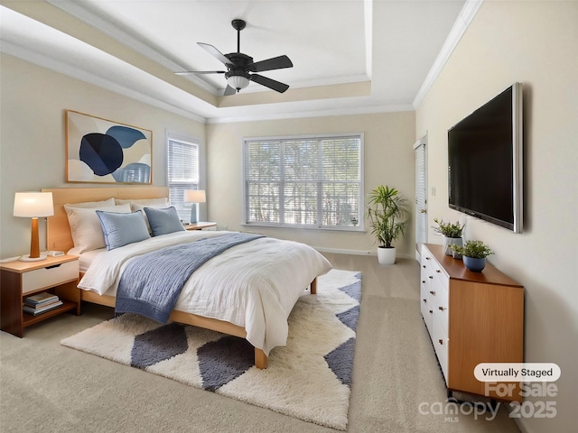 bedroom with light carpet, a tray ceiling, a ceiling fan, and crown molding