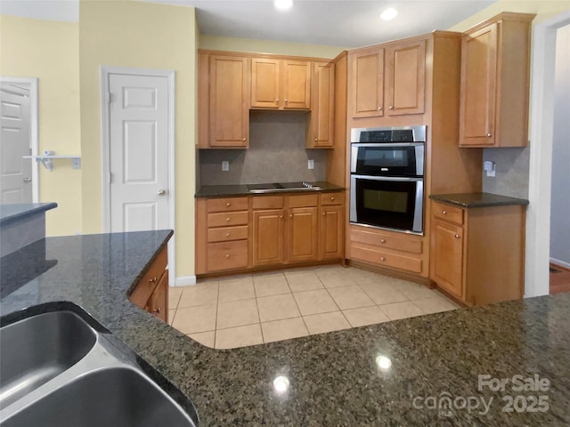 kitchen with light tile patterned floors, double oven, black electric cooktop, recessed lighting, and dark stone countertops