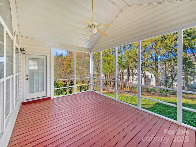 unfurnished sunroom with a ceiling fan and vaulted ceiling