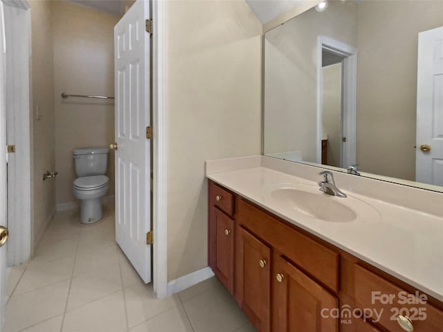 bathroom featuring toilet, tile patterned flooring, baseboards, and vanity