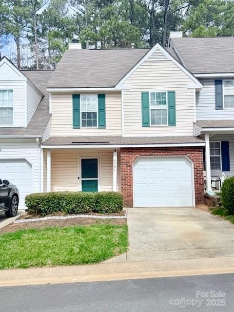 view of front of property with brick siding, an attached garage, a shingled roof, and driveway