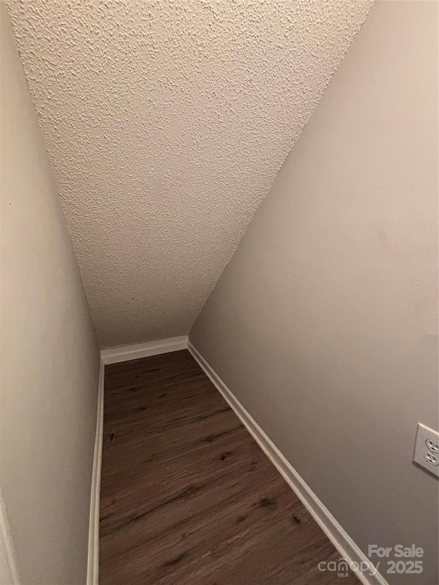 interior details featuring baseboards, wood finished floors, and a textured ceiling