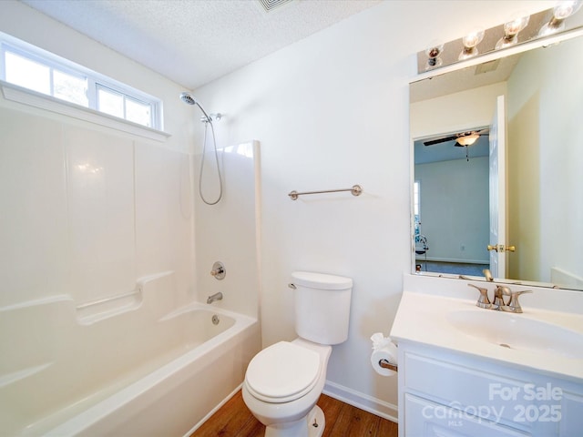 full bath featuring a textured ceiling, bathtub / shower combination, toilet, wood finished floors, and vanity