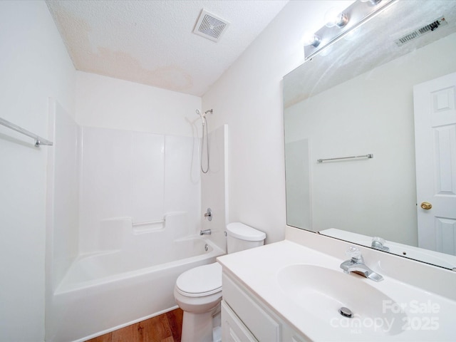 bathroom with visible vents, a textured ceiling, toilet, and wood finished floors